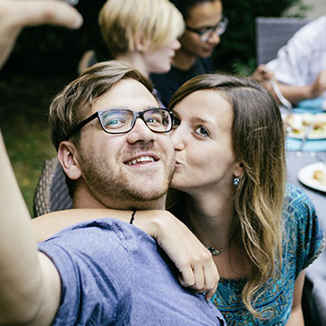 IDEAL UniversalLife: Mittelaltes Paar macht Selfie auf Gartenfest